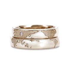 two wedding bands with an elephant and giraffe pattern on them, one is gold