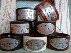 six leather bracelets with words on them sitting in front of an old window frame