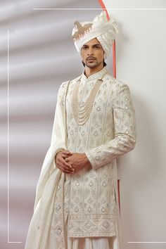 Top Details Color- Off White, Fabric - Soft Blended Silk With Embroidered Bottom Details Color- white, Fabric - Dhupion Silk, Style - free size churidar Package Include :INCLUDES 1 SHERWANI,1 KURTA,1 CHUDIDAR AND 1 STOLE Turban ,Mojari And Other Accessories Are Not Sold Along With The Dress. CARE: DRY CLEAN ONLY Additional Information : - As This Sherwani/Waistcoat/Kurta Are Made As Per Orders So It Is Strictly Not Acceptable Once Get Delivered .So Kindly Choose Body Fit Size . Also We Keep 2 In Embroidered Sherwani For Groom In Transitional Season, Transitional Embroidered Sherwani For Groom, Festive Wedding Kurta With Pearl Embroidery, Cream Kurta With Resham Embroidery For Groom, Cream Kurta With Traditional Drape For Groom, Traditional White Bandhgala For Wedding, Traditional Wear With Pearl Embroidery For Wedding Eid, Cream Traditional Wear With Resham Embroidery For Groom, Embroidered Sherwani For Groom