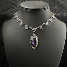 "This elegantly ornate necklace is made with antique silver tone centerpieces, featuring filigree and leaf details. Its mesmerizing design is accented with dazzling dark amethyst purple glass crystals with a large high quality faceted jewel hanging at its center.  Decorated portion is 8 1/2\" wide and 2 1/4\" tall in the very center.  Necklace length is adjustable with soldered stainless steel cable chain, lobster clasp and extender. If you would like a different length, please send us a message. If you don't see items with a color you want, feel free to ask about availability." Gothic Amethyst Necklace, Gothic Filigree Necklace For Wedding, Gothic Wedding Necklace With Filigree Detail, Gothic Filigree Wedding Necklace, Antique Silver Victorian Metal Necklace, Victorian Antique Silver Metal Necklace, Victorian Antique Silver Necklace, Ornate Filigree Silver Bridal Necklace, Ornate Decorative Necklaces For Wedding