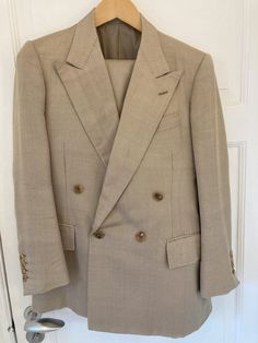 A classic, double-breasted tan suit by the late Edward Sexton of Savile Row 35, made of wool and silk with a stunning herringbone pattern. The iconic, large lapels and roped shoulders alongside details such as hand-sewn buttonholes. The trousers feature two side adjusters and have no pleats. The condition is excellent. Truly a unique and one-of-a-kind suit. An Edward Sexton suit begins at about 5000 euros.  Shoulders: 41cm - 16 inches Sleeve length: 61cm (with 3cm of fabric to let out) - 24 inch Brown Double Breasted Suit For Formal Occasions, Formal Brown Double Breasted Suit, Elegant Brown Double Breasted Suit With Suit Collar, Classic Beige Business Suit, Classic Single Breasted Sets For Fall, Classic Three-piece Wedding Suit With Double Button, Formal Double-breasted Sets For Fall, Classic Beige Suit For Formal Occasions, Classic Beige Suits For Formal Occasions