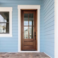 a blue house with white trim and wood door