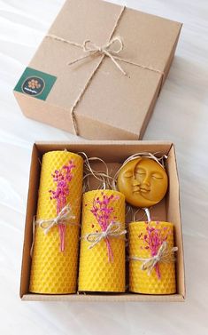 three beeswax candles in a box with a wax stamp on the lid and tied with twine