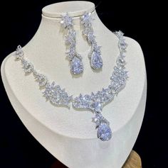 A luxurious two-piece bridal jewelry that will add elegance and sophistication to any wedding gown or formal ensemble! Adorned with intricately faceted cubic zirconia that capture the light from every angle with a perfectly translucent appeal, the pieces are platinum plated for a flawless finish which enhances the intricate detailing and conveys a modern take on old elegance. Necklace: 18" (approx. 45.7cm) long with a secure fold-over closure. Earrings: 1.7" (approx. 4.2cm) long and come with st Elegant Diamond White Crystal Wedding Accessories, Elegant Crystal Bridal Sets With Rhinestones, Elegant Bridal Sets With Rhinestones And Crystal, Elegant White Cubic Zirconia Bridal Sets, White Cubic Zirconia Bridal Accessories For Wedding, Wedding Jewelry Sets In Diamond White With Brilliant Cut, Diamond White Brilliant Cut Jewelry Sets For Wedding, Formal Crystal Bridal Sets With Brilliant Cut, Brilliant Cut Diamond White Jewelry Sets For Wedding