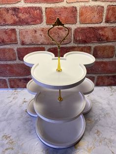 a white mickey mouse cake stand with a gold top