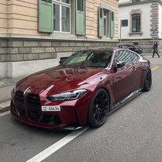 a red sports car parked on the side of the road in front of a building