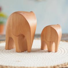 two wooden elephants standing on top of a rug