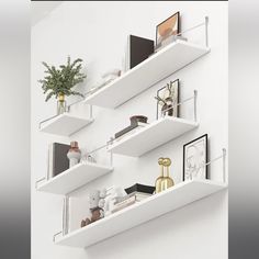 three white shelves with books and pictures on them