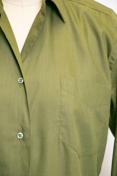 "Vintage 1950s ladies button down blouse in soft moss green cotton blend. Pointed collar. Relaxed yet feminine fit. Simple button front. Long sleeves that need cufflinks, not included. Unlined. Label: Adelaar man tailored shirt - Cotton + Darcon Fits like size: Medium Measurements: Bust: 38\" - 40\" pit tp pit Waist: 36\" Length: 22.5\" Shoulder to shoulder: 16\" Sleeve: 24\" Condition: Very good/good. Very minor under arm fade and a few faint marks that look oil based which didn't lift with soa Classic Green Tops With Spread Collar, Classic Plain Cotton Blouse, Classic Green Shirt With Pockets, Khaki Collared Office Shirt, Green Cotton Office Blouse, Khaki Collared Shirt For Office, Classic Khaki Shirt With Buttons, Green Cotton Blouse For The Office, Classic Khaki Shirt