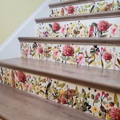 some flowers painted on the wall next to stairs and handrails in a home