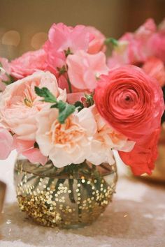 a vase filled with pink and red flowers on top of a table