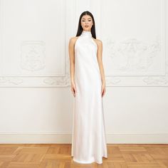 With its modern yet timeless appeal, the Jasmine Halterneck Silk Dress showcases Il Volo’s elevated approach to ready-to-wear. Crafted from white double silk satin in a flattering bias cut, it drapes elegantly over the silhouette. For a playful and feminine look, you can transform the silk tie neck into a chic bow, or you can let it drape loosely, adding a touch of laid-back sophistication to your ensemble.  Wear it with flats for an effortlessly refined look or dress it up with a precious pair Elegant Satin Finish Daywear Dress, Elegant White Slip Dress For Formal Occasions, White Satin Finish Slip Dress For Evening, White Silk Dress With Back Opening, White Satin High Neck Dress, Elegant White Formal Slip Dress, Elegant Silk Satin Dress For Daywear, White Satin Dress For Daywear, Elegant White Silk Evening Dress