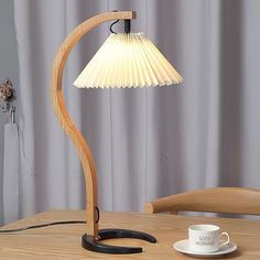 a wooden table with a lamp on top of it and a cup next to it