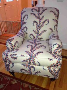 a blue and white chair sitting on top of a hard wood floor next to a doorway