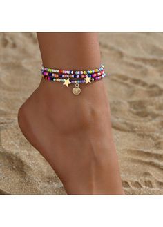 a woman's foot wearing colorful beaded ankle bracelets with star charms on it