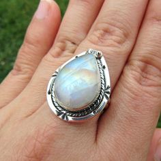 SKU: SS-061Material: 925 stamped sterling silverGemstone(s): Rainbow Moonstone (N)Gemstone Dimensions: 13 X 19 X 4 mmRing Size: US 8Weight: 8.1 gramsThis eye-catching Rainbow Moonstone ring features a teardrop Rainbow Moonstone cabochon, set in a classic bezel with a modern braid border that accents the stone beautifully. This Rainbow Moonstone lives up to its name, showcasing blue, orange and yellow fire all throughout the stone. Teardrop Moonstone Ring In Sterling Silver, Sterling Silver Teardrop Moonstone Ring Gift, Silver Teardrop Moonstone Ring For Anniversary, Adjustable Teardrop Moonstone Ring In Sterling Silver, Sterling Silver Teardrop Moonstone Ring, Teardrop Moonstone Gemstone Ring, Silver Teardrop Moonstone Ring, Silver Teardrop Gemstones, Silver Teardrop Moonstone Ring In Sterling Silver