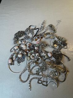 This is a 1/2 pound lot of broken and not, vintage and newer craft jewelry. The majority of these are wearable or for craft Silver tones There are necklaces, earrings, bracelets, key rings, broken pieces etc etc. Both vintage and modern. Perfect for your slow stitches or scrapbooking projects. Or other works of art This is NOT a mystery bag or box, so there will be no surprises You get everything in the picture. So study the pictures carefully !! Various materials such as plastic, metal, beads, Vintage Silver Jewelry With Unique Variations, Elegant Assorted Jewelry For Gift, Unique Party Jewelry With Charms, Vintage Charms For Crafting Jewelry, Vintage Handmade Assorted Jewelry, Handmade Vintage Jewelry In Assorted Colors, Assorted Vintage Handmade Jewelry, Assorted Jewelry Making Supplies, Handmade Assorted Jewelry In Various Shapes