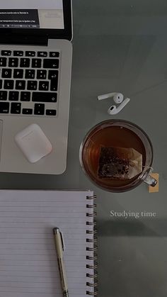 an open laptop computer sitting on top of a desk next to a cup of coffee