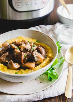 a white bowl filled with meat and grits next to an instant pressure cooker