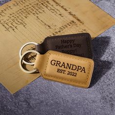 two personalized leather keychains sitting on top of a piece of old paper