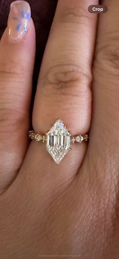 a woman's hand with a ring on it and a diamond in the middle