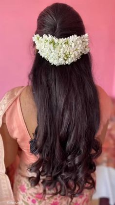 a woman with long dark hair wearing a flowered headband on top of her head