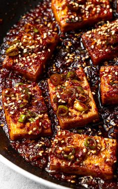 tofu with sesame seeds and sauce in a pan