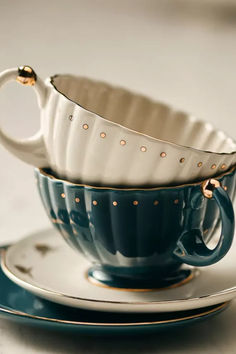 a tea cup and saucer sitting on top of a plate next to each other