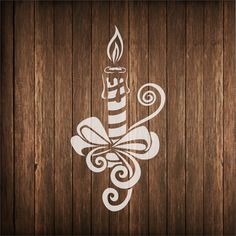 a wooden wall with a lit candle and swirls on the wood paneled surface