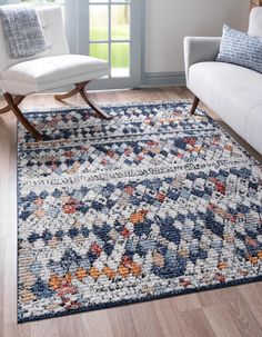 a living room area with a couch, chair and rug