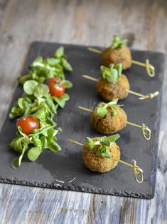 small appetizers are arranged on a slate plate