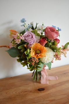 a bouquet of flowers sitting on top of a wooden table