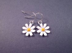 Silver daisy charms (15mm) with white and yellow enamel lacquer, on silver french hook ear wires. These earrings measure one and 1/8 inches in length Same daisies in gold here: https://www.etsy.com/listing/31960845/daisy-earrings-white-and-yellow-enamel See more of my designs here; BohoDreamJewelry.etsy.com And please visit my sister~shops; justCHARMING.etsy.com & justEARRINGS.etsy.com  All of my jewelry shops offer FREE SHIPPING! Highlights: handmade jewelry, daisy earrings, silver charms, whit Adjustable Yellow Daisy Jewelry, Yellow Enamel Earrings, White Daisy Flower Charm Earrings, Yellow Enamel Jewelry With Charms, Yellow Enamel Flower Shaped Jewelry, Daisy Charm, Daisy Earrings, Silver Earrings Dangle, Silver Charms