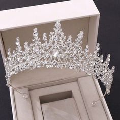 a white box with a gold tiara in it