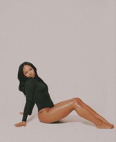 a woman is laying on the floor with her legs spread out and wearing black clothing