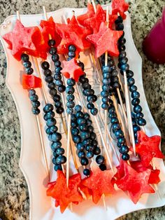 an arrangement of food on a plate with toothpicks and watermelon stars