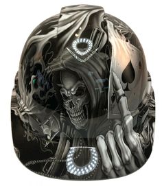 a motorcycle helmet with a skeleton holding a knife in it's right hand and skull on the left side