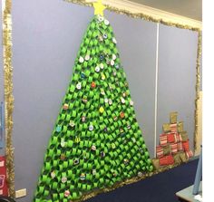 a christmas tree made out of green wrapping paper on a bulletin board in an office cubicle