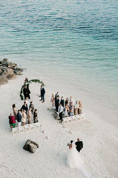 an aerial view of a wedding ceremony on the beach