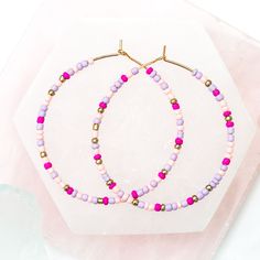 Add a bit of color to your wardrobe with the Ashli Beaded Hoop Earrings. Beaded with various shades of pinks, creams, and lavender, these delicate seed bead hoop earrings bring both style and interest to any outfit. Fish Hook with rubber backing Nickel Free Hypoallergenic Pink Tiny Beaded Earrings, Pink Hoop Beaded Earrings With Tiny Beads, Pink Tiny Beads Hoop Earrings, Pink Hoop Earrings With Dangling Beads For Gift, Pink Hoop Earrings With Tiny Beads As Gift, Pink Hoop Earrings With Tiny Beads For Gift, Pink Small Hoop Beaded Earrings As Gift, Trendy Pink Beaded Earrings With Round Beads, Trendy Pink Hoop Earrings With Round Beads