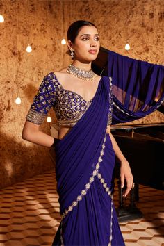 Indulge in elegance with this gorgeous purple drape sari in georgette, featuring exquisite embroidery detailing at the bottom and on the palla. The fully embroidered blouse adds a touch of sophistication to the ensemble. Padded for comfort, the blouse is designed with a side zip closure for a seamless fit. Elevate your style with this meticulously crafted outfit that exudes grace and timeless beauty. Silk Anarkali Saree With Draped Style, Anarkali Silk Saree, Traditional Draped Cutdana Blouse Piece, Traditional Draped Blouse Piece With Cutdana, Unstitched Draped Anarkali Blouse, Anarkali Saree With Draped Unstitched Blouse, Unstitched Anarkali Traditional Wear With Draped Blouse, Anarkali Saree With Unstitched Blouse, Draped Blouse Piece With Zari Work For Diwali