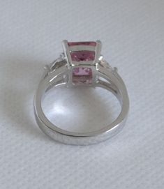 "This pink faceted glass rhinestone ring has clear triangle shaped rhinestones on each side and is on a silver tone setting. This ring is a size 6.75 (see photos). The main stone measures approximately 3/8\" by just over 1/4\". This ring is in excellent vintage condition. This ring is not marked. This ring will come in a box, ready for gifting if you so choose. Don't forget to Favorite our shop so you can find us again as we are always adding new items. We'd love to have you follow us at: Facebo Pink Sterling Silver Crystal Ring For Formal Occasions, Silver Pear-shaped Crystal Ring For Formal Occasions, Pink Pear-shaped Cubic Zirconia Ring, Pink Rings With Accent Stones For Party, Pink Rhinestone Rings For Gifts, Pink Rhinestone Wedding Rings, Pink Party Rings With Accent Stones, Elegant Pink Trillion-cut Jewelry, Elegant Pink Crystal Ring