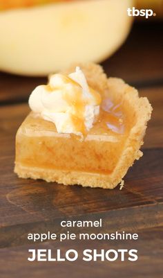 a close up of a piece of food on a wooden table with the words caramel apple pie moonsshine jello shots