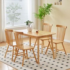 a dining room table with chairs and a potted plant