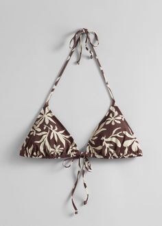 Triangle bikini halterneck top detailed with a bow at the front and the neck. Featuring removable padding. Chic Triangle Halter Top For Sunbathing, Chic Triangle Halter Top For Beach Season, Brown Triangle Halter Top For Beachwear, Brown Triangle Halter Top For Vacation, Bra Friendly Triangle Halter Top For Vacation, Bra-friendly Triangle Halter Top For Vacation, Brown Triangle Halter Top For Beach Season, Chic T-back Swimwear For Beach, Brown Halter Neck Top For Beach Season