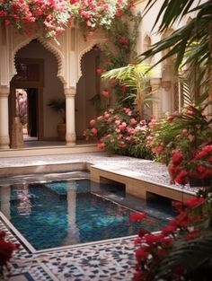 an indoor swimming pool surrounded by flowers and greenery in the middle of a courtyard