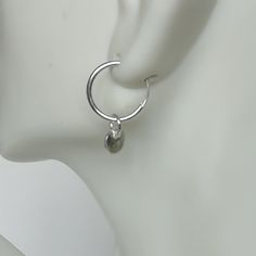 A PAIR of sterling silver hoops. Comes with a detachable tiny and delicate round disc charm. The charm is multipurpose and can be used with a neck or bracelet chain too. Dimension: Hoop- 12x1.2 mm Charm- 5 mm Drop length- 17 mm Price listed is for ONE PAIR These are made of 925 hypoallergenic sterling silver. Most of my pieces come with a 925 stamp. Can be packaged in a gift box. I can include a personal message from you if needed You are welcome to contact me at... bhavnakwintra1956@gmail.com F Modern Nickel Free Round Cartilage Earrings, Modern Nickel-free Round Cartilage Earrings, Silver Minimalist Huggie Dangle Earrings, Minimalist Silver Dangle Huggie Earrings, Minimalist Metal Round Huggie Earrings, Minimalist Round Metal Huggie Earrings, Minimalist Huggie Dangle Earrings With Charms, Charm Small Hoop Metal Earrings, Silver Charm Hoop Earrings