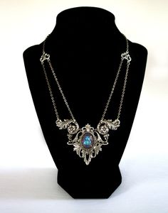 "Gothic Victorian necklace , elven necklace , Art Nouveau statement necklace with crystal , Edwardian necklace , Victorian necklace A unique, Gothic Victorian necklace that adds an elegant statment to any outift!  This Victorian Necklace features an 18 x 13 mm premium cut glass crystal. The crystal color in photos is the color \"Lagoon\" but you can choose your crystal color in the drop down menu (examples of other colors can be seen in the last photo). The crystal is set into gorgeous ornate detailed silver filigree with subtle art nouveau elements. Necklace is finished with antique silver soldered link chain that secures at the back with a lobster clasp. This statement necklace is bold yet very lightweight on the neck.  DETAILS * Chain is 14 inches long - necklace hangs higher on the nec Silver Gothic Necklaces For Fantasy Events, Silver Necklace For Fantasy Events, Handmade Gothic Jewelry For Fantasy Events, Elegant Silver Jewelry For Fantasy Events, Silver Bohemian Jewelry For Fantasy Events, Elven Style Metal Jewelry For Gifts, Elven Style Metal Jewelry Gift, Fantasy Pendant Jewelry For Fantasy Events, Gothic Pendant Necklace With Jewels