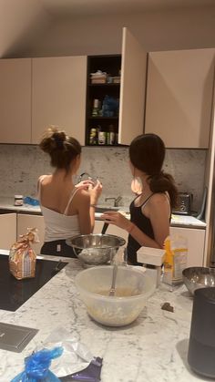 two women are in the kitchen making something