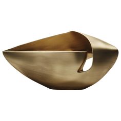 an abstract brass bowl with a curved design on the front and side, against a white background